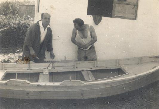 Enrique (a la derecha) pintando la embarcación