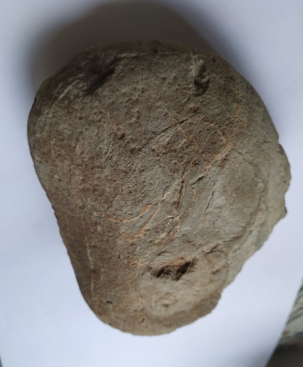 Figura 8 B. Acha de pedra neolítica (votiva). Presenta na cara anterior dúas raias inclinadas en na parte posterior tres ocos simulando unha cabeza (idoliño-antropomorfo). Aparecida a 350 m. ó sur do xacemento. Ofrenda de amortización dunha medorra (necrópole)